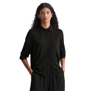 female model with hands in pocket wearing marc o polo shirt in black colour