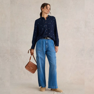 female model looking away from camera wearing whitestuff organic cotton shirt in navy colour