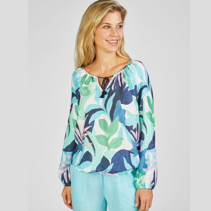 female model looking away from camera wearing rabe leaf pattern top in aqua colour 