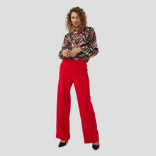 Load image into Gallery viewer, Blouse on model paired with red trousers 
