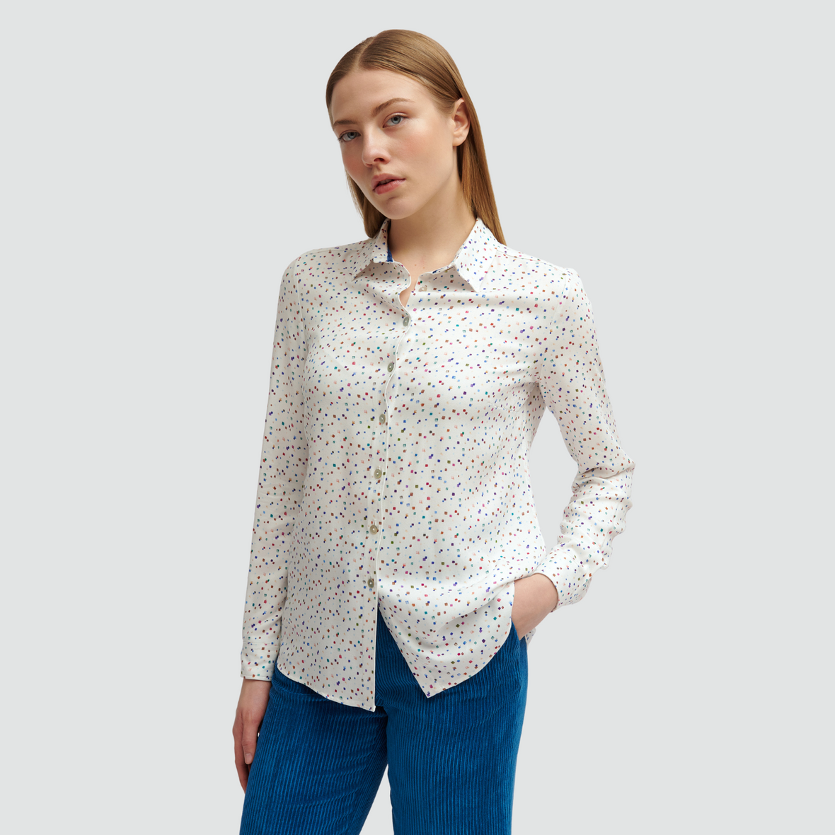 female model with hands in pockets wearing Tinta Malu Blouse in creamy white