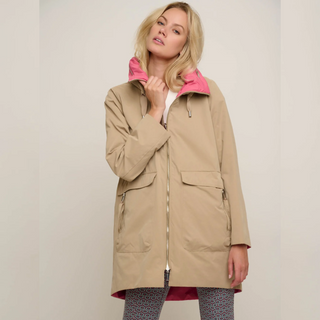 female model wearing rino & pelle reversible coat in sand colour looking at camera