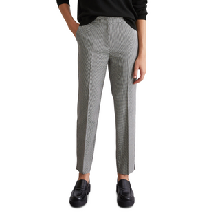 female model with hands in pockets wearing marco polo trousers in black white colours 